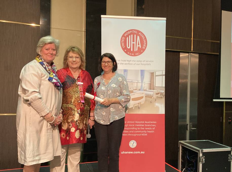 Queanbeyan Hospital auxiliary treasurer Lynda McIntosh accepts awards from UHA NSW president Tracey Wilkinson and QHA president Karen Campbell.